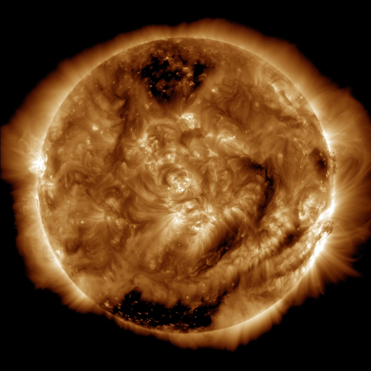 A false-color extreme-ultraviolet NASA observation of the Sun with bright active regions and dark coronal holes.
